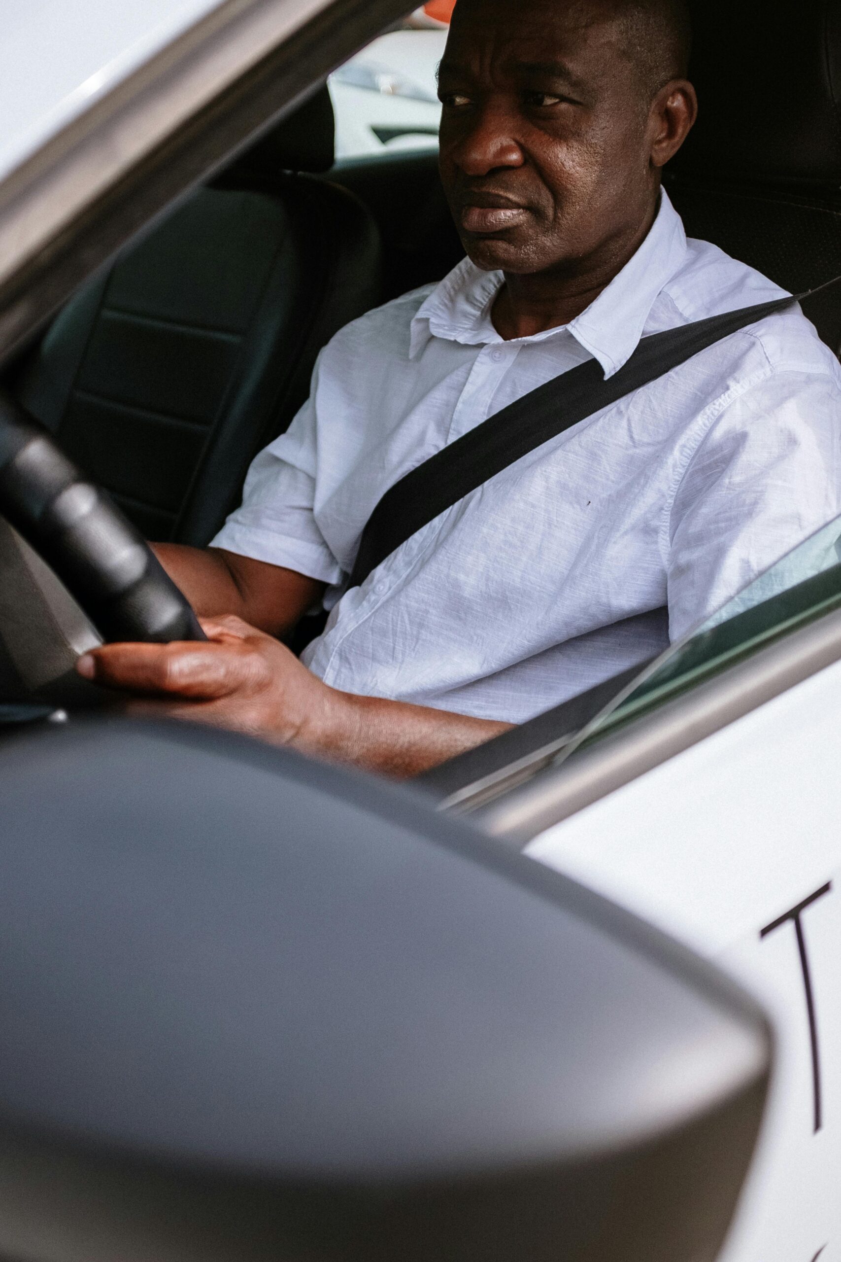 Man driving a car, focused on the road, representing transportation service.